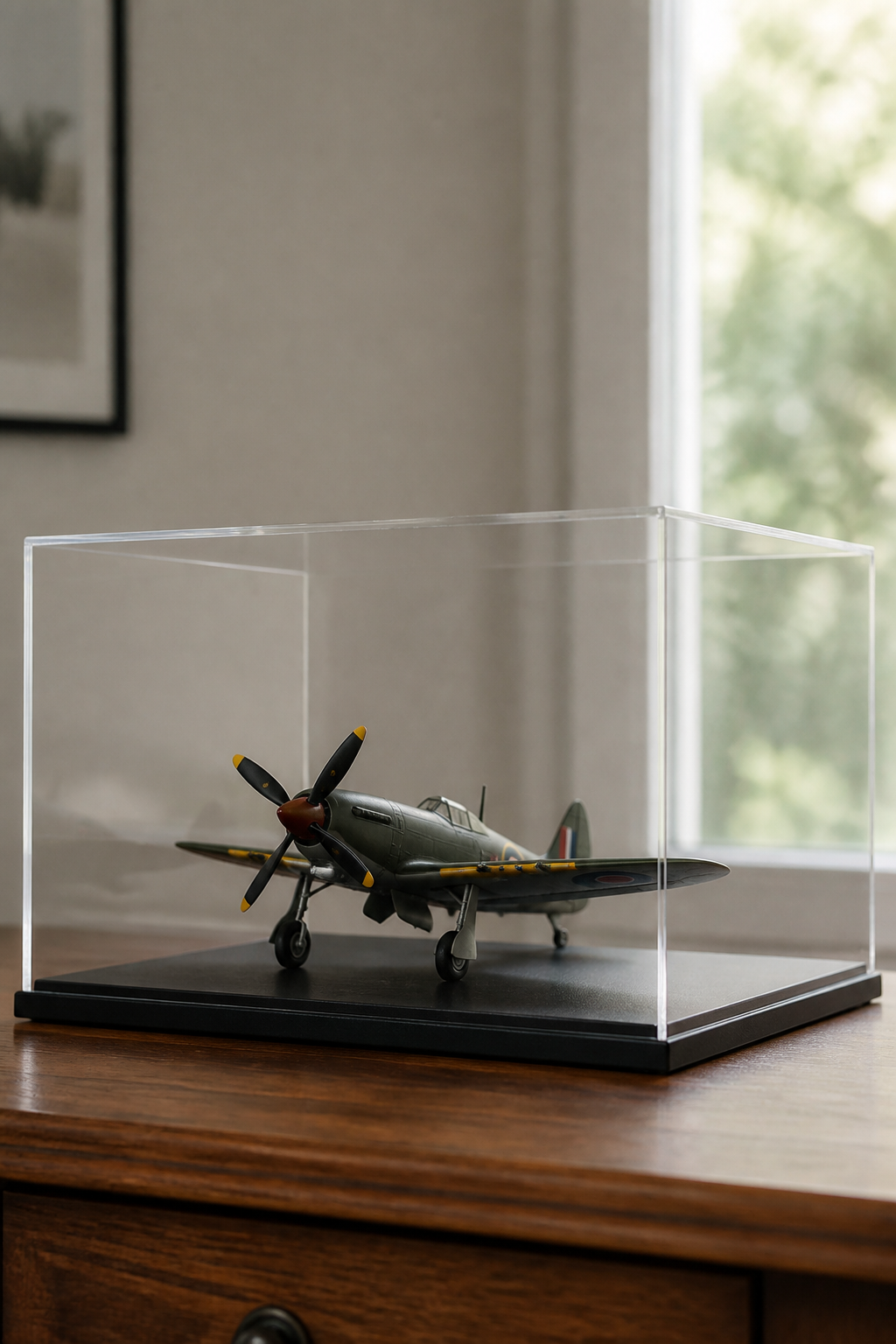 A clear acrylic display case with a dark base holding a single propeller aircraft model