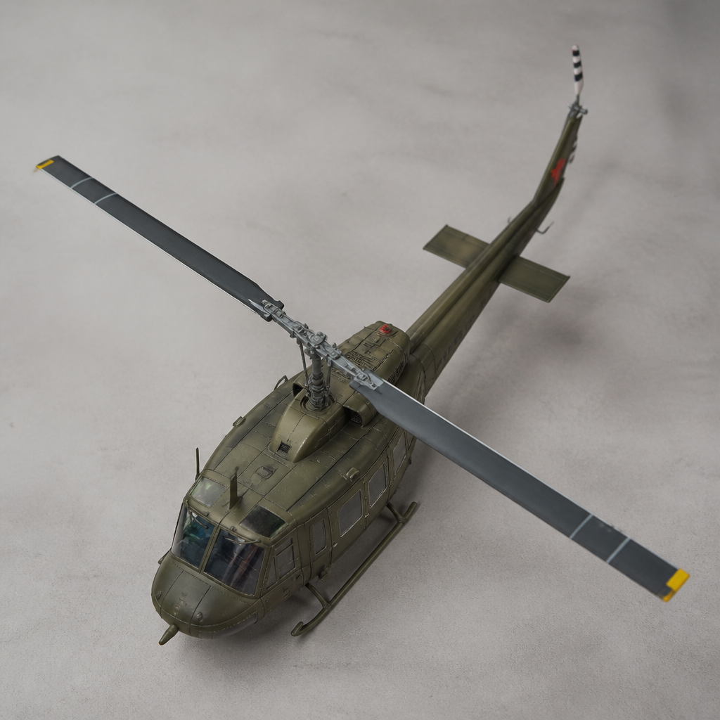 A 1/48 utility helicopter model with its rotor blades fitted, photographed from above against a plain background