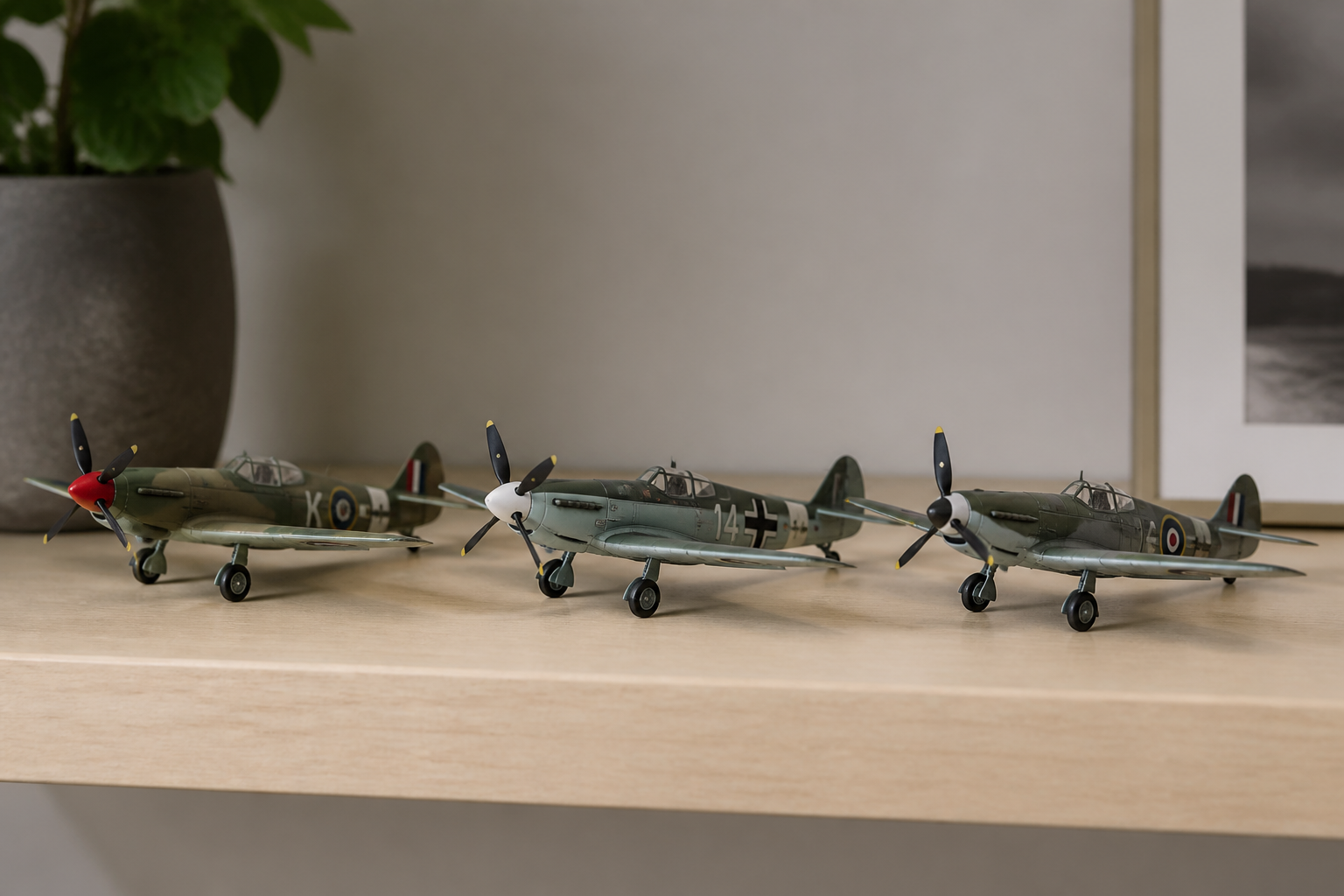 Three wartime fighter models in camouflage finish standing wingtip to wingtip on a shelf